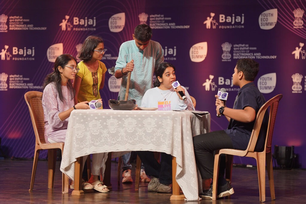 Students speaking into microphones during a Youth Eco Summit stage performance