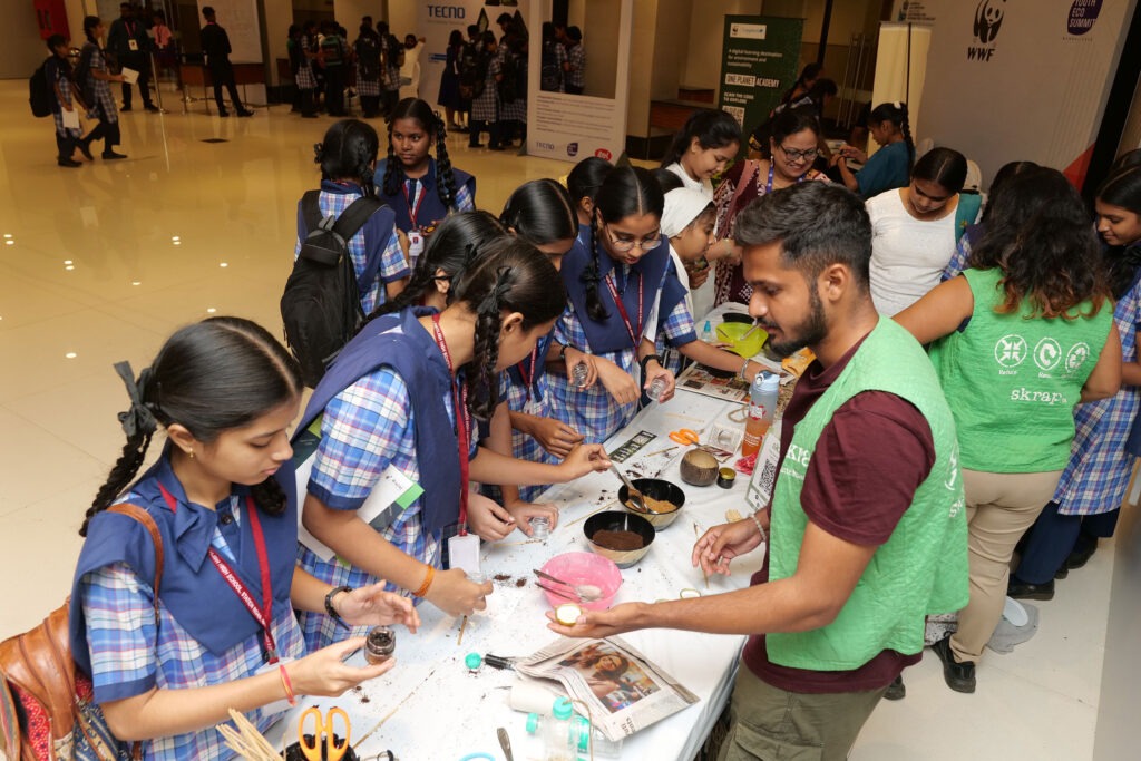 Students making crafts with facilitators at a summit workshop